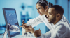 image of laboratory professionals looking at computer screen in a lab